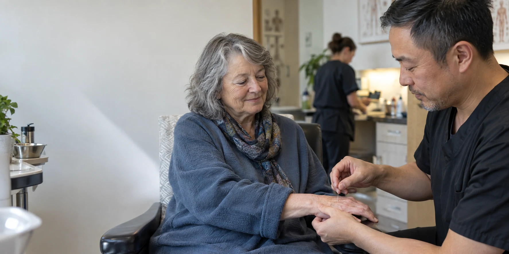 A practitioner placing an acupuncture needle in a patient's hand